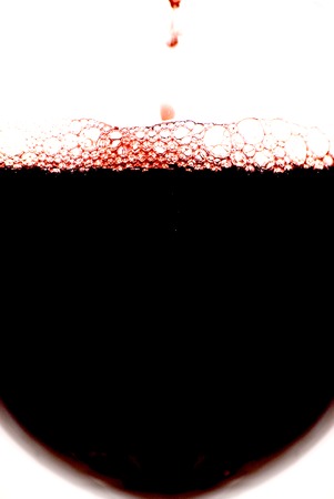 Glass of red wine with splash on white backgroundの写真素材