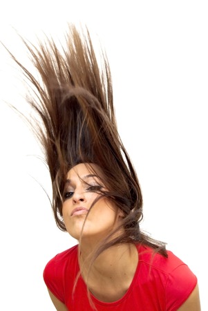 Portrait of Beautiful Young Woman Shaking Her Hair Over White Backgroundの写真素材