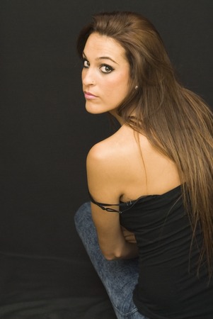 Portrait of Beautiful Young Woman Back Over Black Backgroundの写真素材