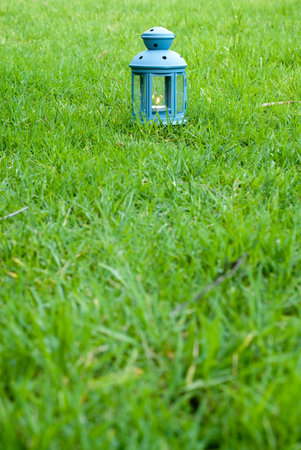 Blue Lantern, with burning candle inside, on green grass - stock imageの写真素材