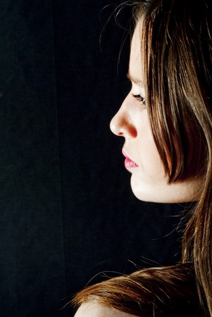 Portrait of Beautiful Young Woman Over Black Backgroundの写真素材