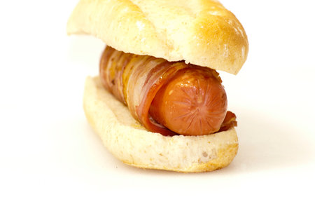 Hot dog with bacon on a white background の写真素材