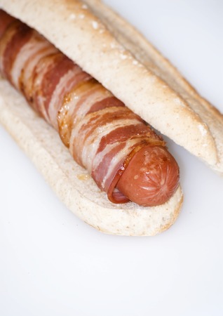 Hot dog with bacon on a white background の写真素材
