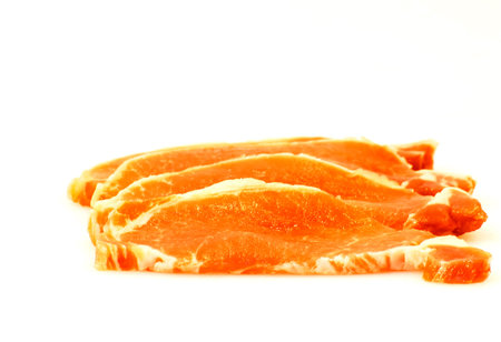 Piece of raw meat cut into steaks on white background の写真素材