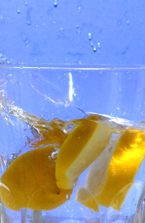 Lemon falling into the clear water of a crystal vase, making bubbles and wavesの写真素材
