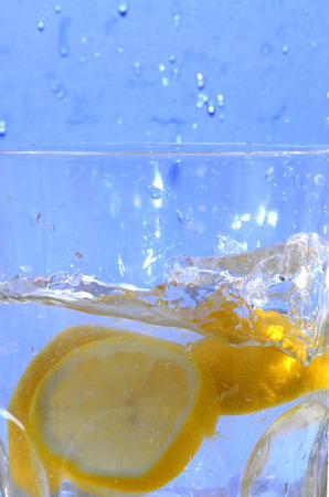 Lemon falling into the clear water of a crystal vase, making bubbles and wavesの写真素材