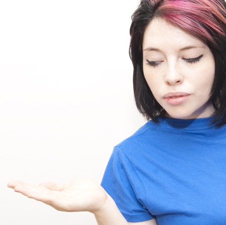 Portrait of Beautiful Young Woman  with a red tuft and His Open Hand Over White Backgroundの写真素材