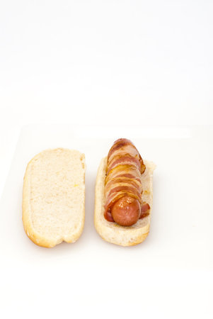 Hot dog with bacon on a white background の写真素材