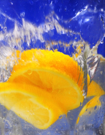 Lemon falling into the clear water of a crystal vase, making bubbles and wavesの写真素材