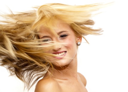 Portrait of Beautiful Blonde Woman Shaking Her Hair Over White Backgroundの写真素材