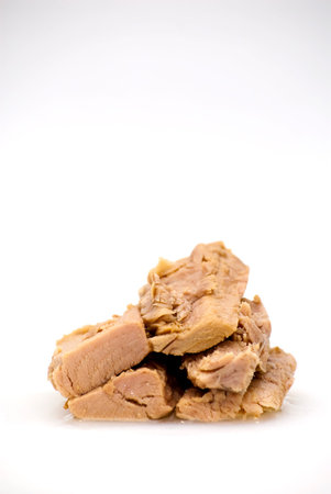 Group of pieces of tuna in olive oil over white background 