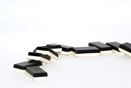 Row of dominoes fallen over white backgroundの写真素材