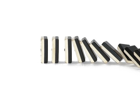 Row of dominoes falling over white backgroundの写真素材