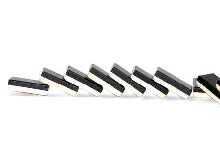 Row of dominoes fallen over white backgroundの写真素材