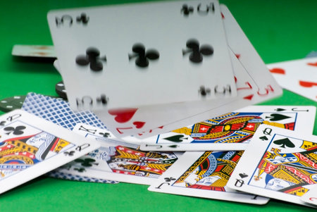 Cards and gambling chips over green background