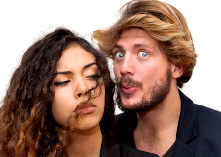 Beautiful portrait of a loving couple  on white background. She is angry and he tries to reconcile....