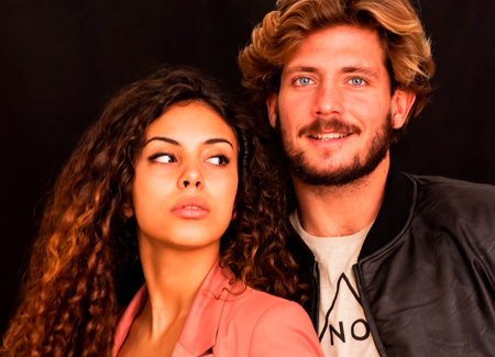 Beautiful portrait of a loving couple  on black background.