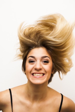 Portrait of Beautiful Young Woman Shaking Her Hair Over White Backgroundの写真素材