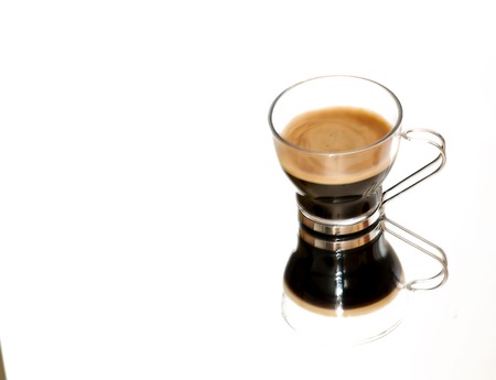 Coffee cup on a mirror on white backgroundの写真素材