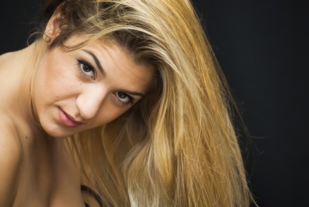 Portrait of Beautiful Young Woman Over Black Backgroundの写真素材