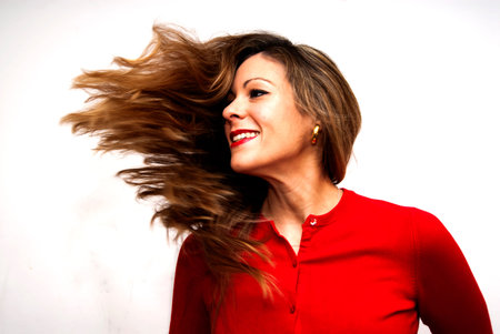 Portrait of Beautiful Young Woman Shaking Her Hair Over White Background
