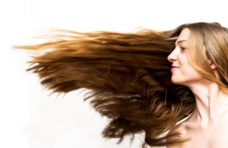 Portrait of Beautiful Young Woman Shaking Her Hair Over White Backgroundの写真素材