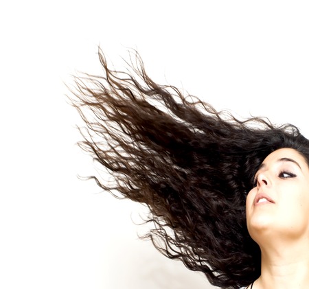 Portrait of Beautiful Young Woman Shaking Her Hair Over White Backgroundの写真素材