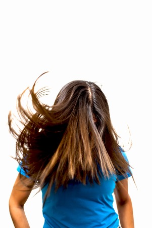 Portrait of Beautiful Young Woman Shaking Her Hair Over White Backgroundの写真素材