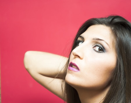 Portrait of Beautiful Young Woman Over Red Backgroundの写真素材