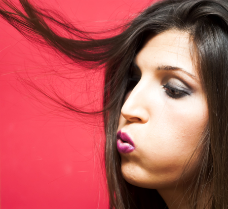 Portrait of Beautiful Young Woman Over Red Backgroundの写真素材