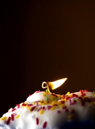 Cupcake with a lit candle  in an moody atmosphereの写真素材