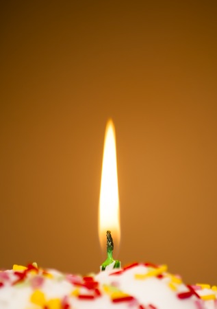 Cupcake with a lit candle  in an moody atmosphereの写真素材