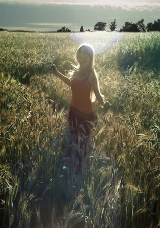Beautiful blond woman in a wheat field at sunset  backlitの写真素材
