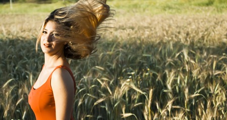 Beautiful blond woman in a wheat field at sunset  backlitの写真素材
