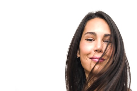 Portrait of Beautiful Young Woman Shaking Her Hair Over White Backgroundの写真素材
