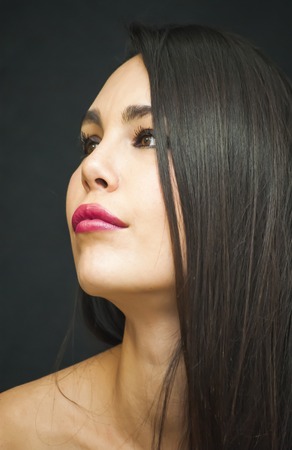 Portrait of Beautiful Young Woman Over Black Backgroundの写真素材