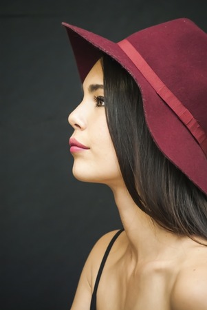 Portrait of Beautiful Young Woman With Red  Hat Over Black Backgroundの写真素材