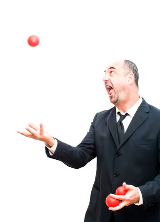 Businessman  that is juggling with a red balls over whiteの写真素材