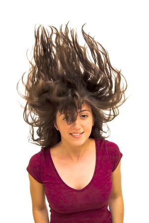 Portrait of Beautiful Young Woman Shaking Her Hair Over White Backgroundの写真素材