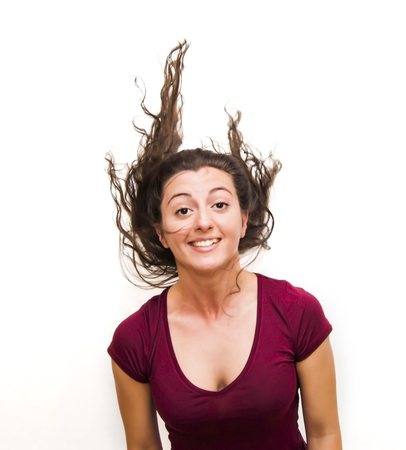 Portrait of Beautiful Young Woman Shaking Her Hair Over White Backgroundの写真素材