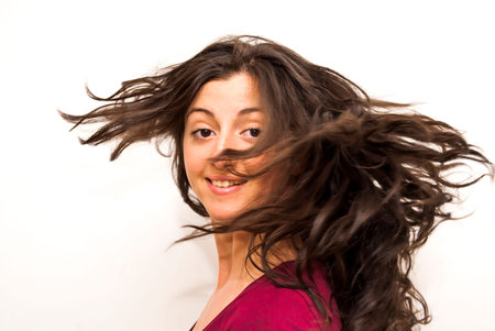 Portrait of Beautiful Young Woman Shaking Her Hair Over White Background
