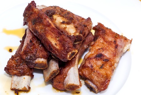 Roasted pork ribs on a white plateの写真素材