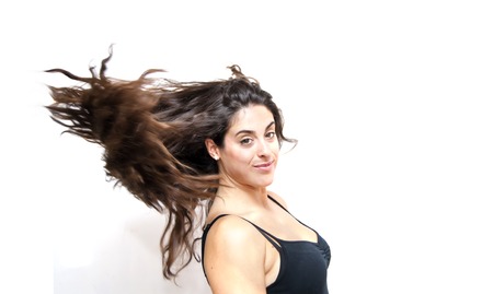 Portrait of Beautiful Young Woman Shaking Her Hair Over White Backgroundの写真素材