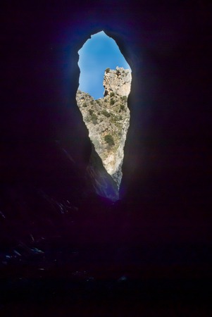 View of the entrance of a cave from inside the cave out of the caveの写真素材