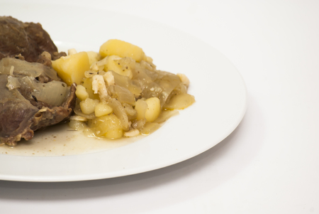 Tasty Pork cheeks with potatoes on a white plateの写真素材