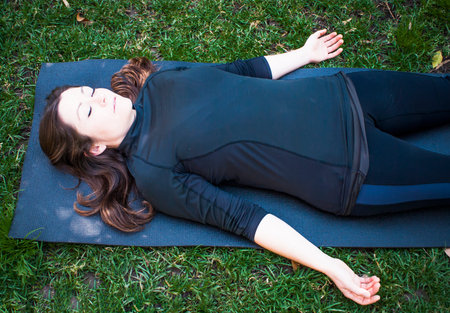 Beautiful woman practicing yoga in the parkの写真素材