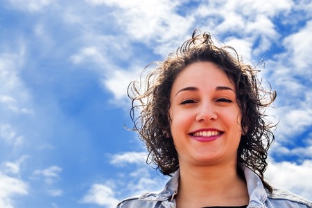 Beautiful woman with a sky with clouds backgroundの写真素材