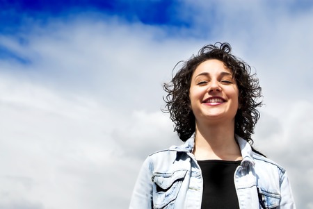 Beautiful woman with a sky with clouds backgroundの写真素材