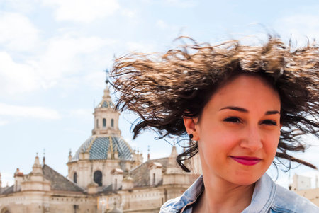 Beautiful woman with a sky with clouds and a church background