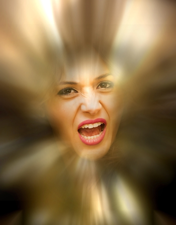 Portrait of a beautiful woman screaming on urban light backgroundの写真素材
